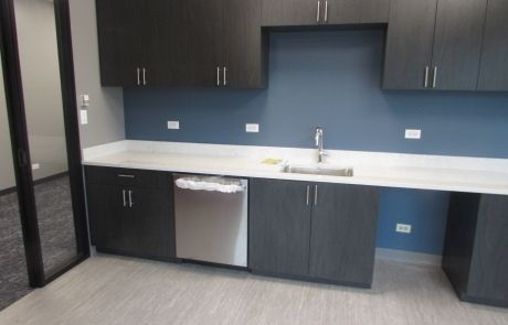 A kitchen with a sink , dishwasher , and cabinets.