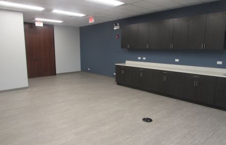 An empty room with a sink and cabinets in it