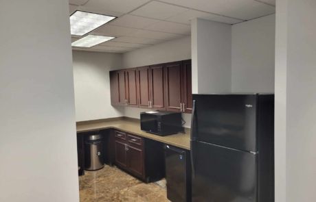 A kitchen with a black refrigerator , microwave , and dishwasher.