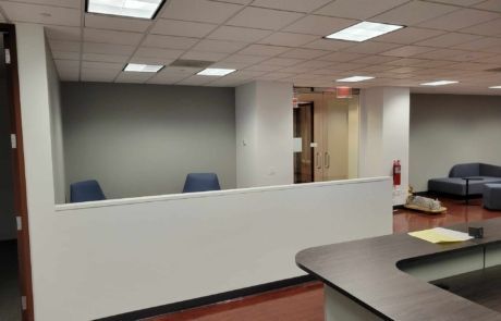 An empty office with a desk and chairs in it