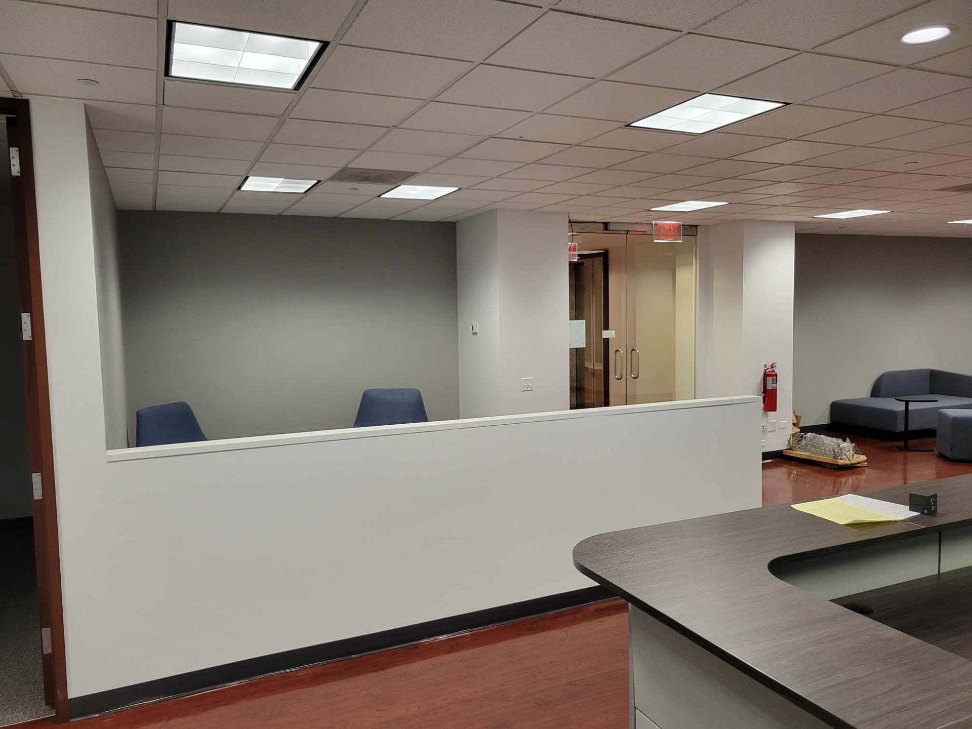 An empty office with a desk and chairs in it