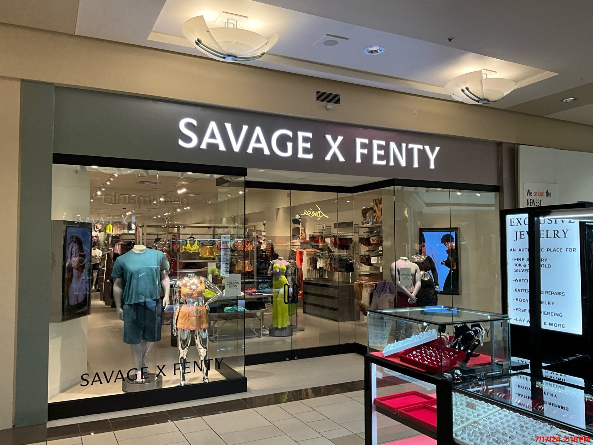 A savage x fenty store in a mall with mannequins in front of it.