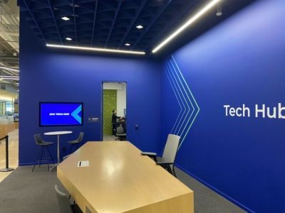 A room with a table and chairs and a sign that says tech hub