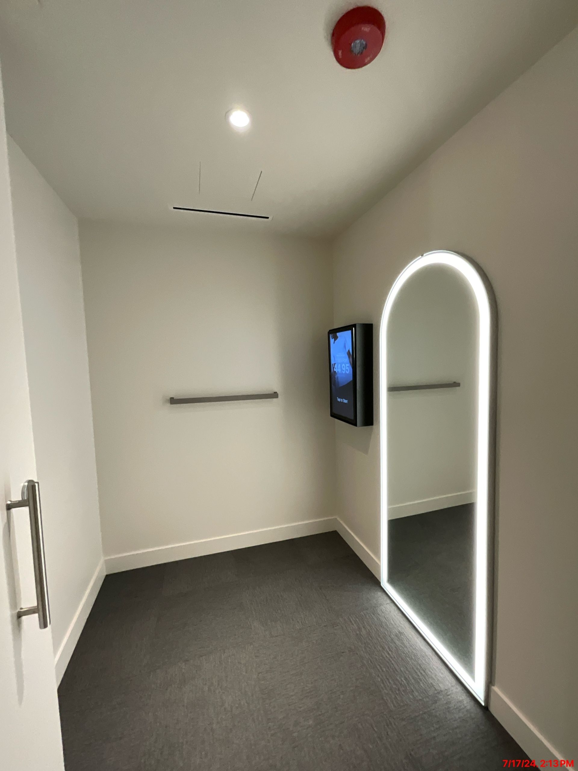 A room with a large mirror and a tv on the wall