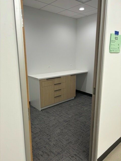 A room with a desk and drawers in it