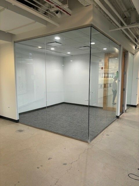A room with a glass wall and a carpeted floor