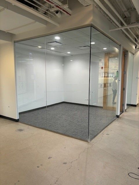A room with a glass wall and a carpeted floor