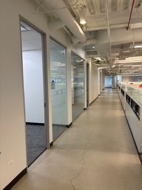 A long hallway in an office building with glass doors
