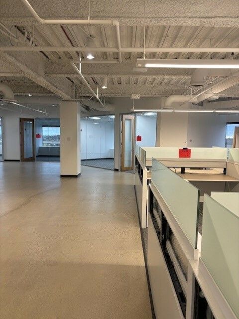 An empty office with cubicles and a red box on the desk