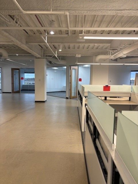 An empty office with cubicles and a red bag on the desk