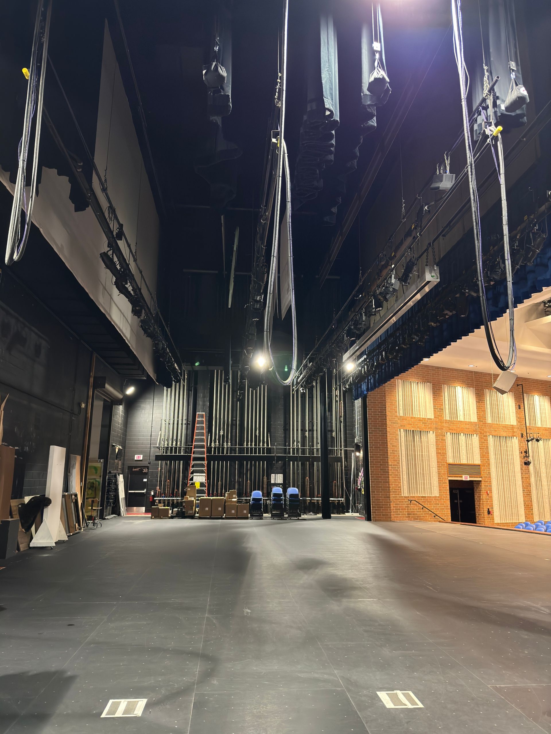 An empty auditorium with a lot of lights hanging from the ceiling