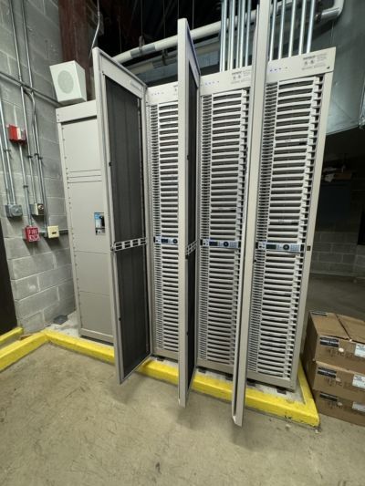 A row of metal cabinets with their doors open in a room.