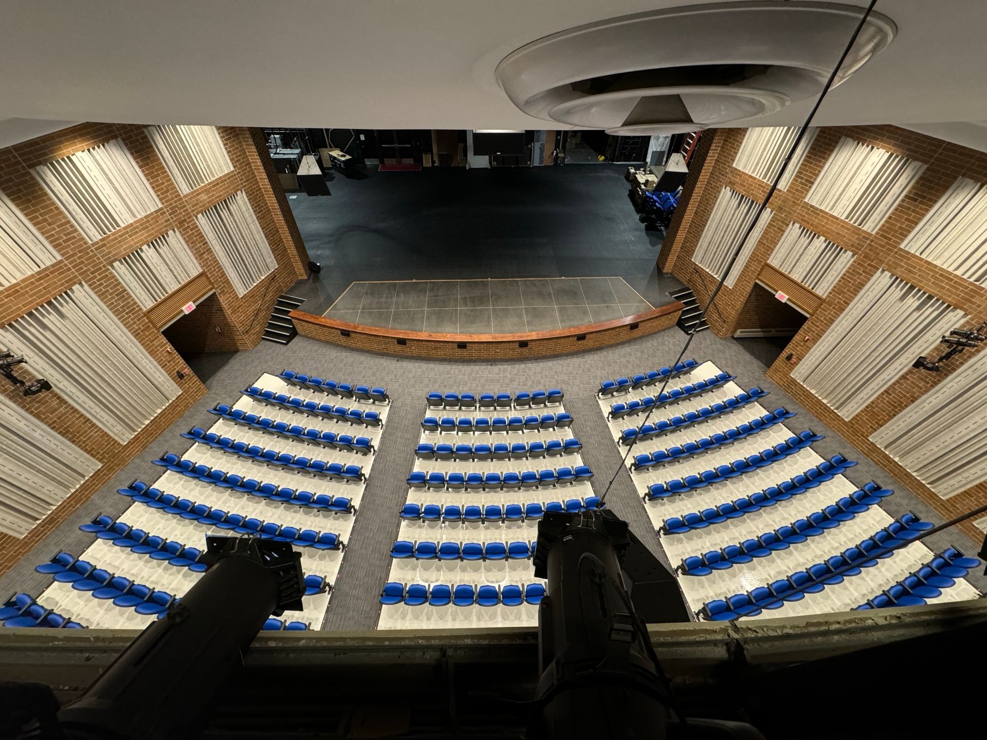 An aerial view of a large auditorium with blue and white seats.