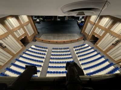 An aerial view of a large auditorium with blue and white seats.