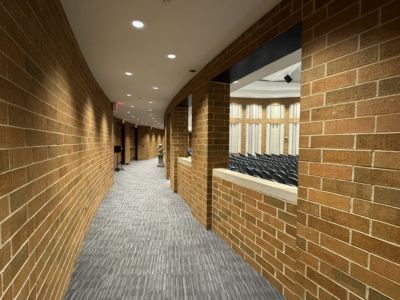 A long hallway with brick walls and a window