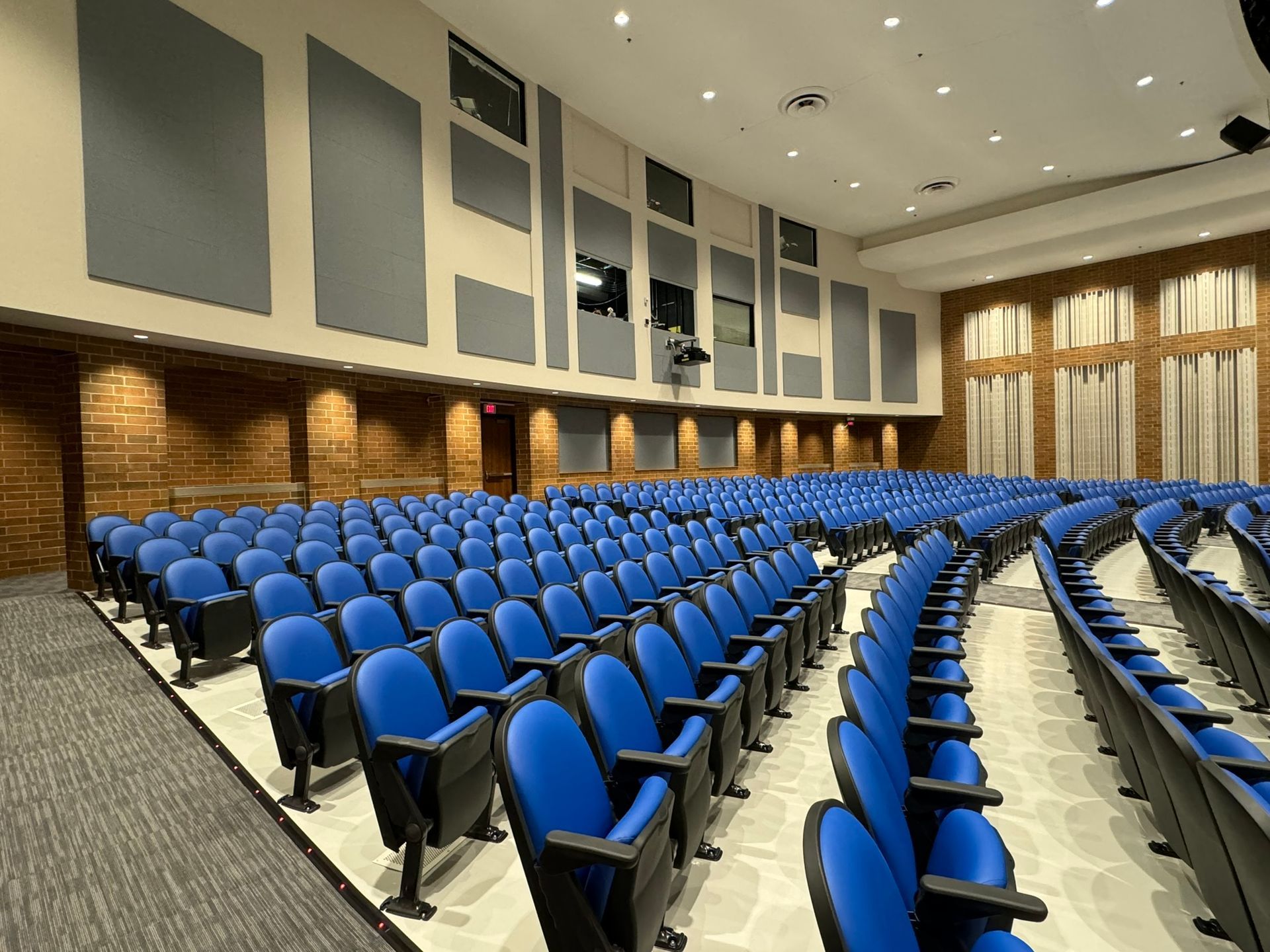 Rows of blue chairs in a large auditorium