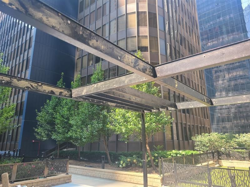 A view of a city park with trees and buildings in the background - Elgin, IL - Omni Commercial Group, Inc