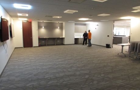 Two men are standing in a large empty room