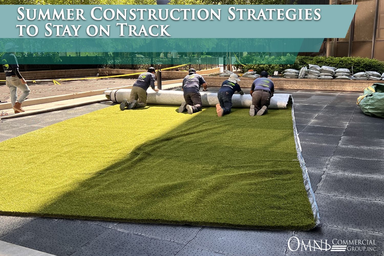 A group of people are working on a synthetic grass field.