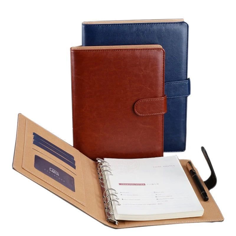 Un classeur en cuir marron et bleu avec un stylo