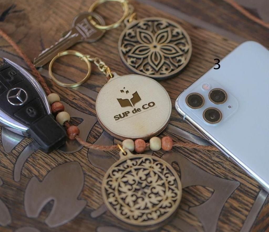 Un porte-clés en bois avec le mot sup dessus