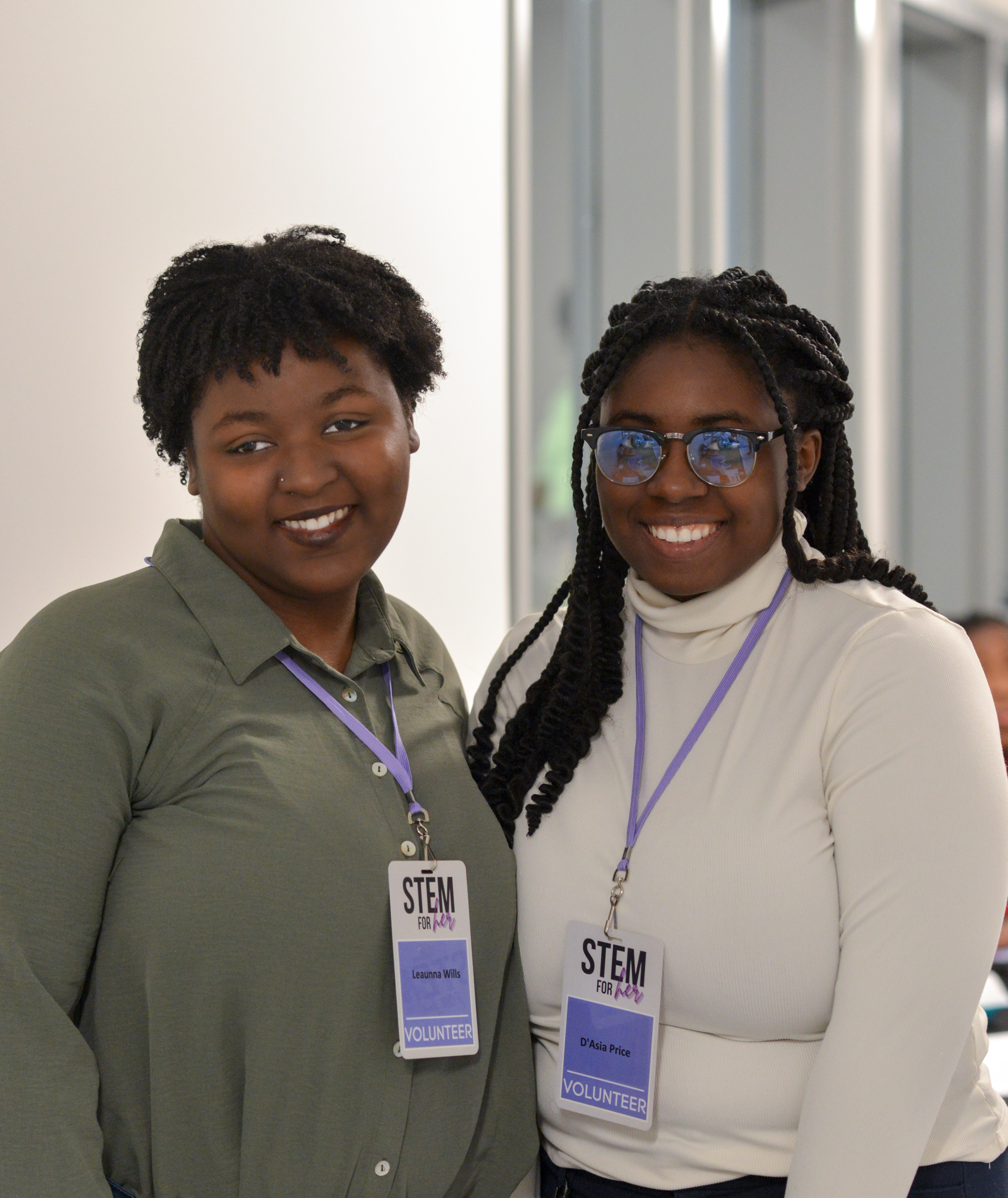 Two women are posing for a picture and one has a name tag that says stem