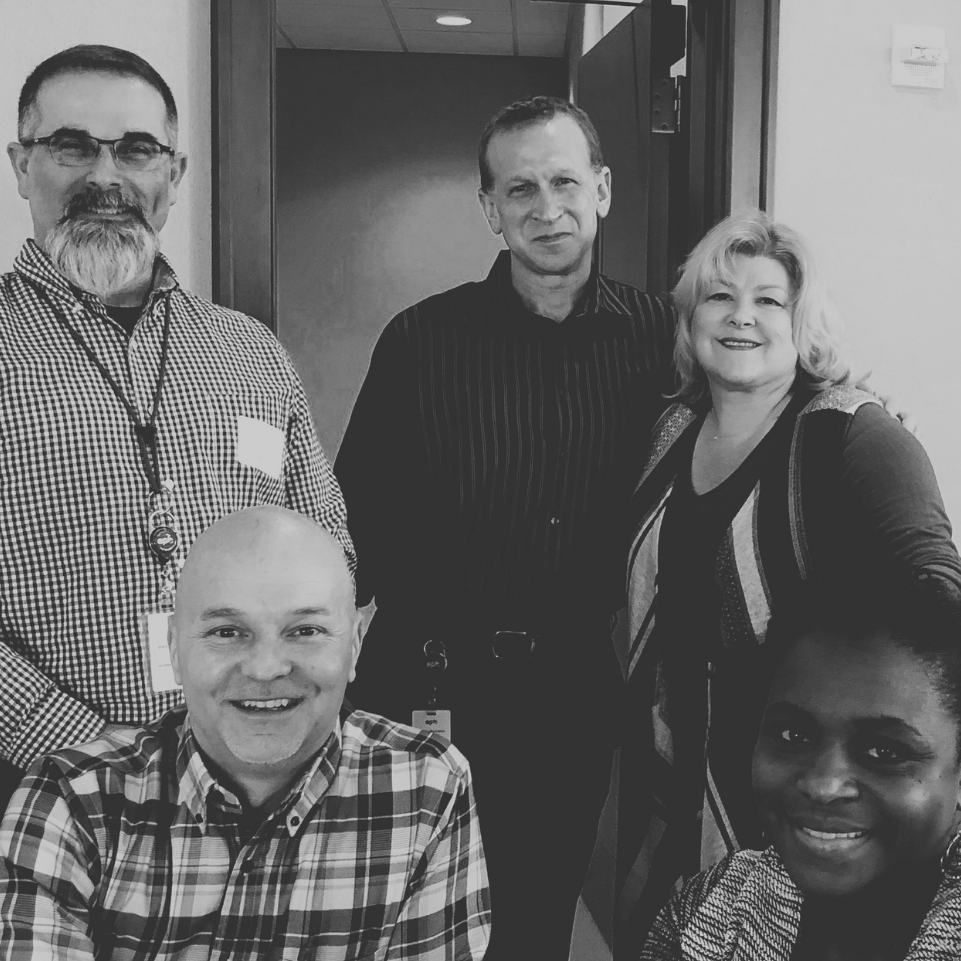 A black and white photo of a group of people posing for a picture
