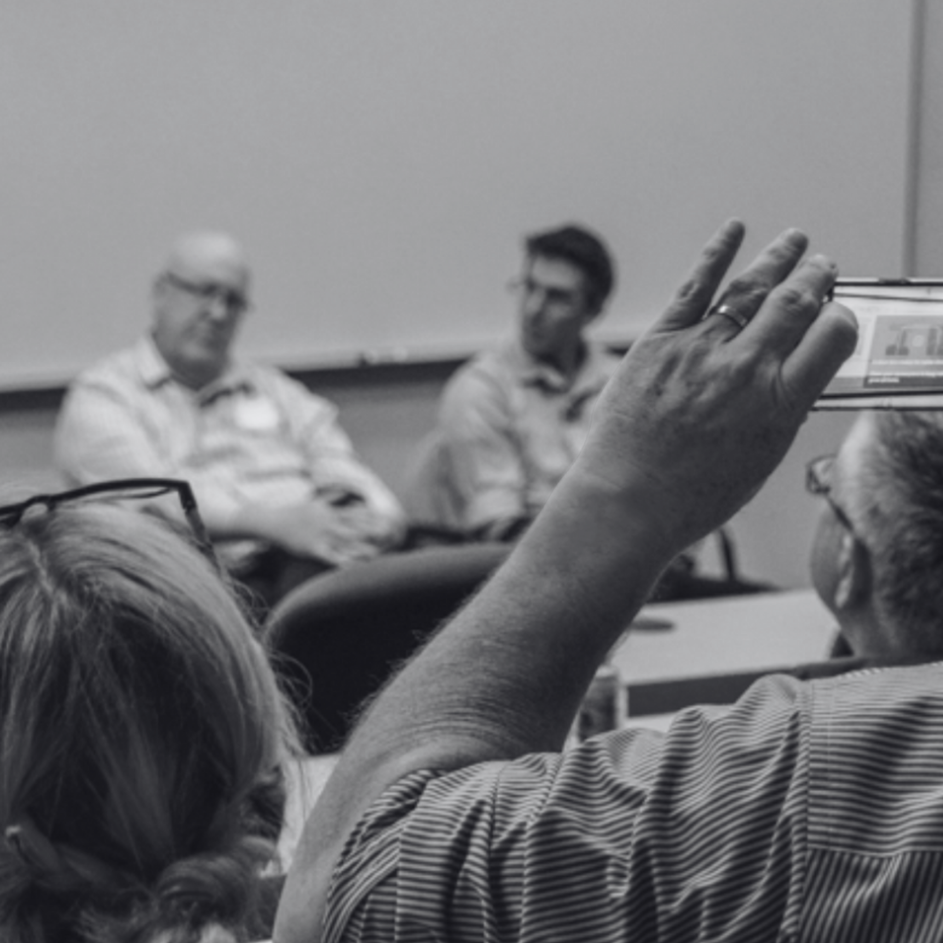 A black and white photo of a man taking a picture of a group of people