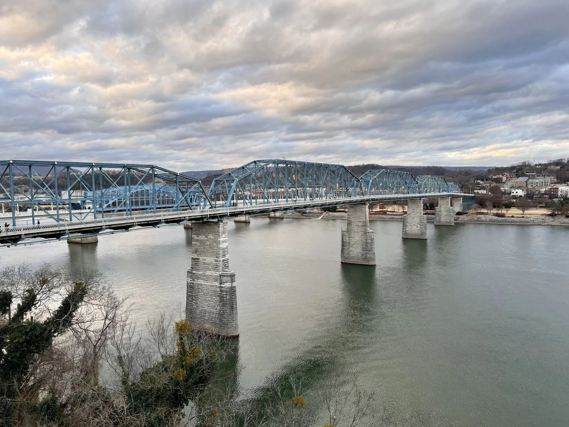 A bridge over a body of water with a cloudy sky in the background.