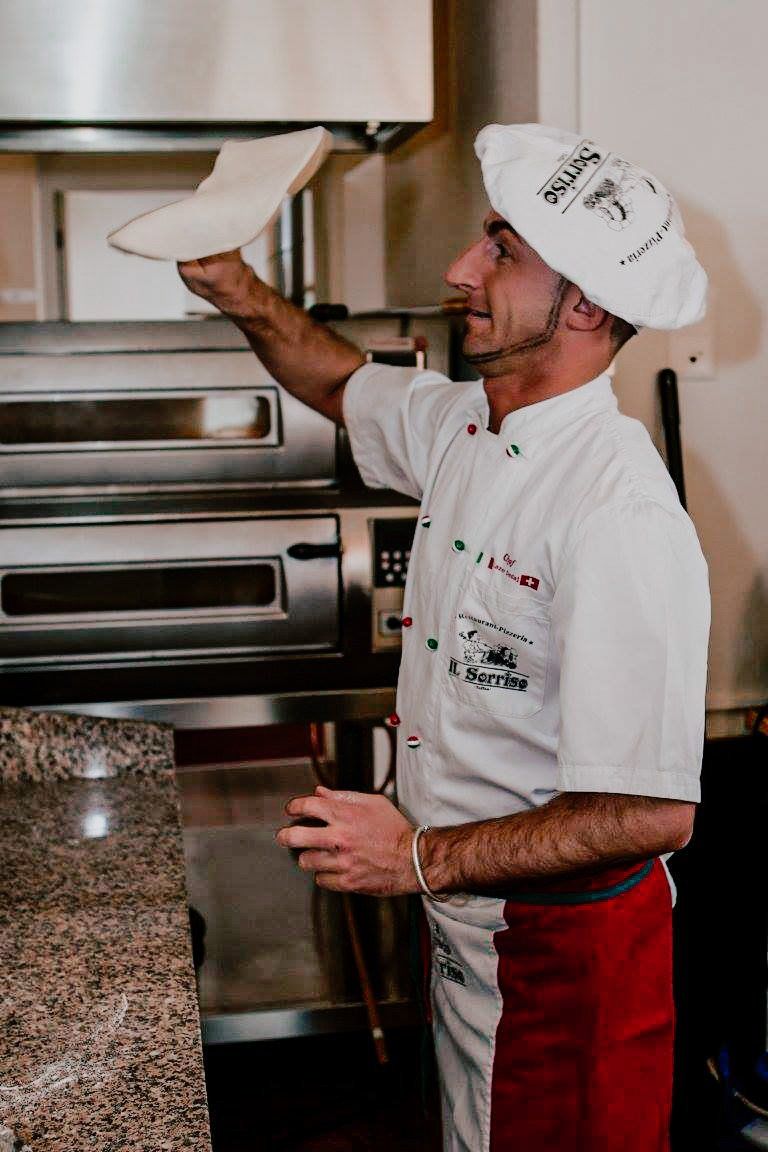 der Küchenchef bereitet die Pizza zu