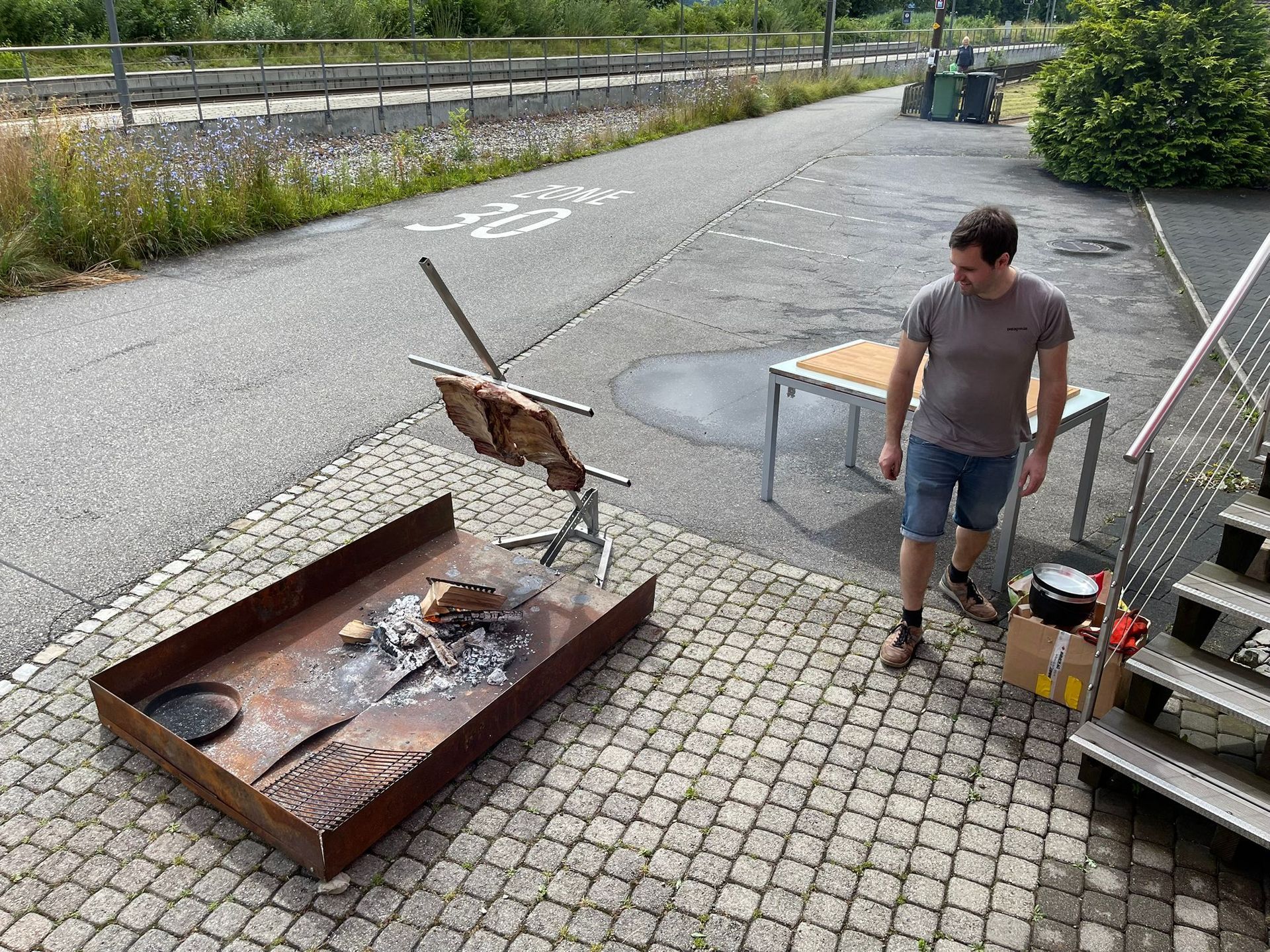Un homme se tient à côté d'un foyer sur un trottoir.