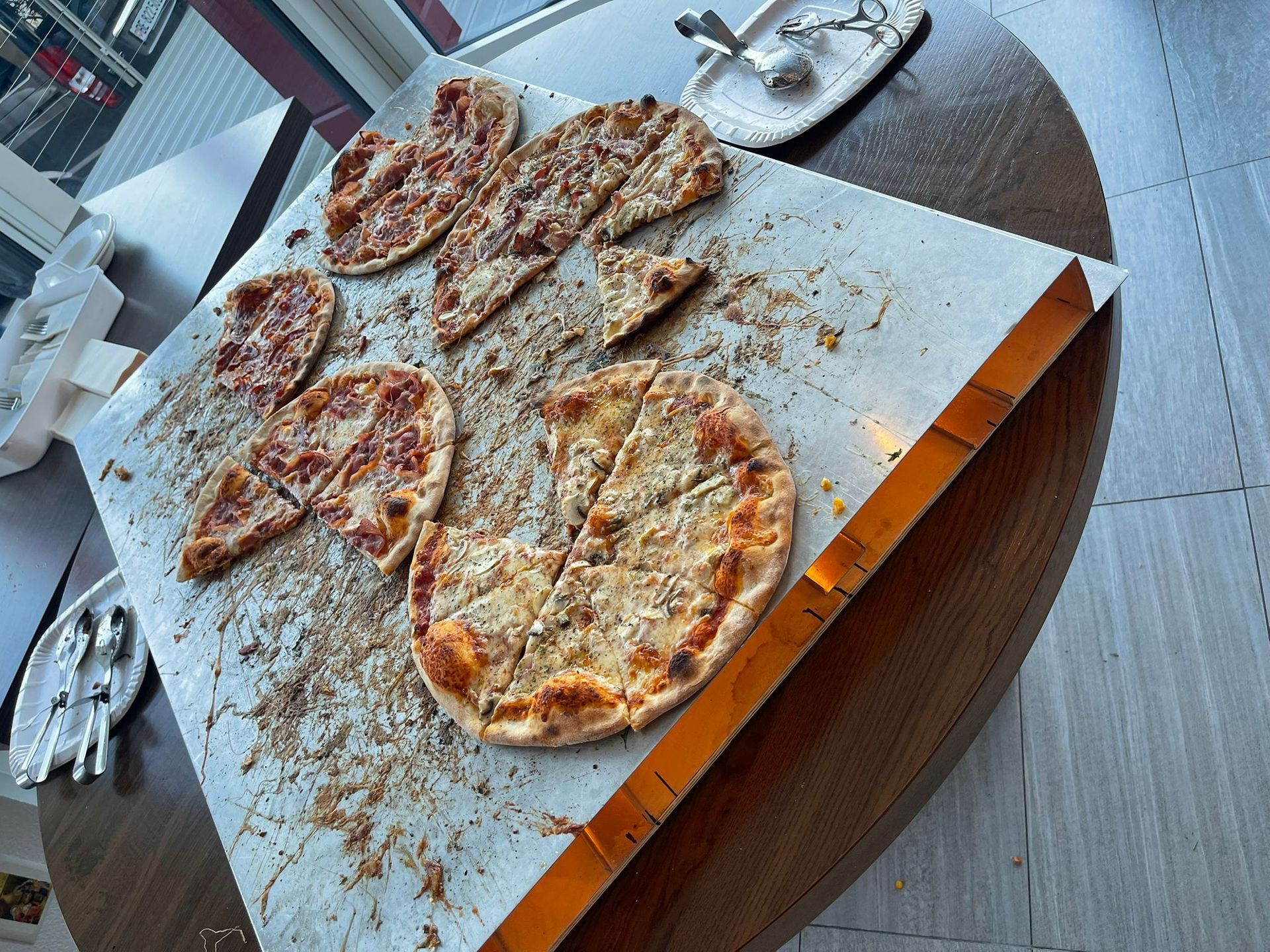 Un tas de pizzas sont posées sur une table en bois.