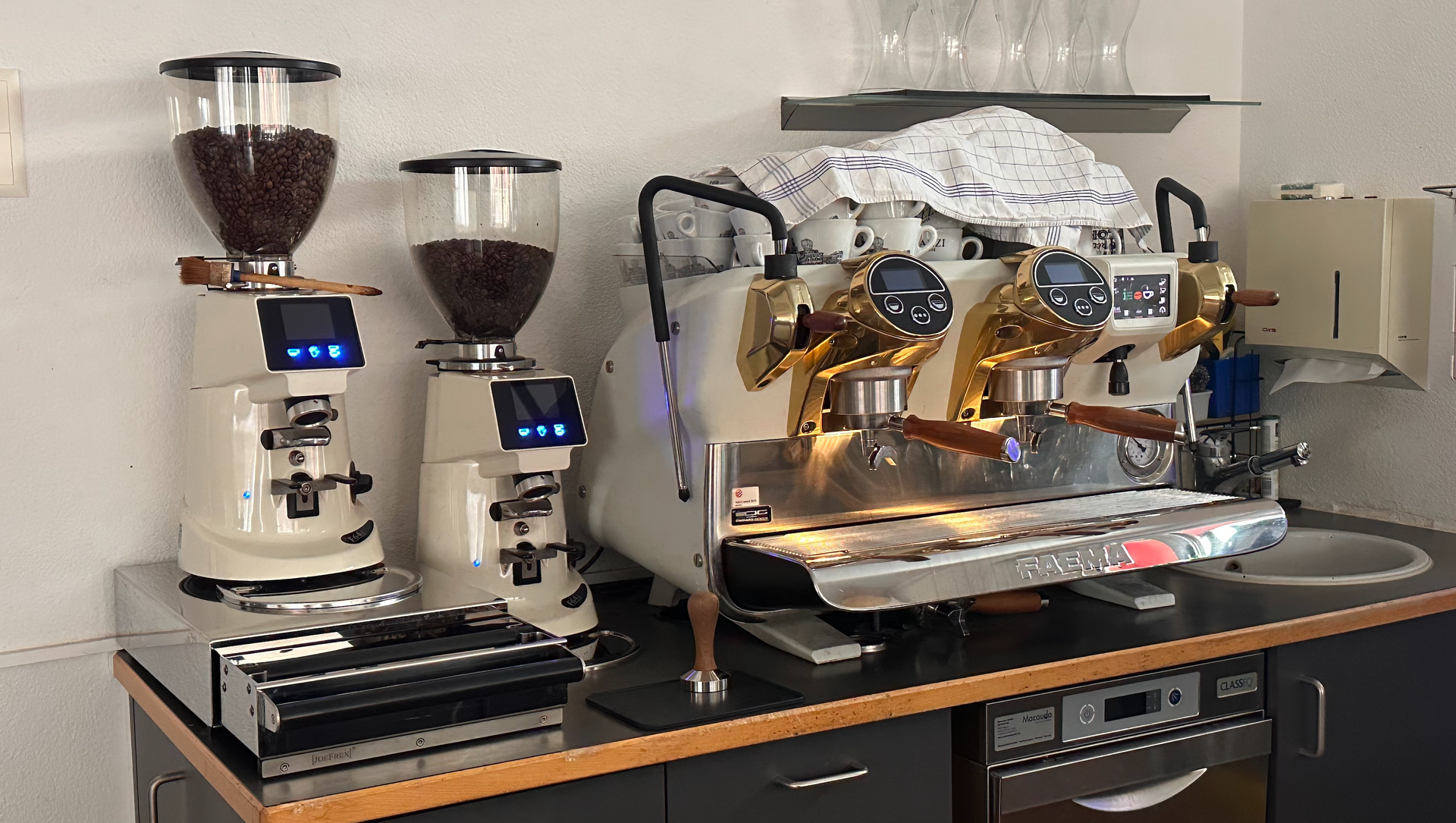 Deux moulins à café sont posés sur un comptoir à côté d'une machine à café.
