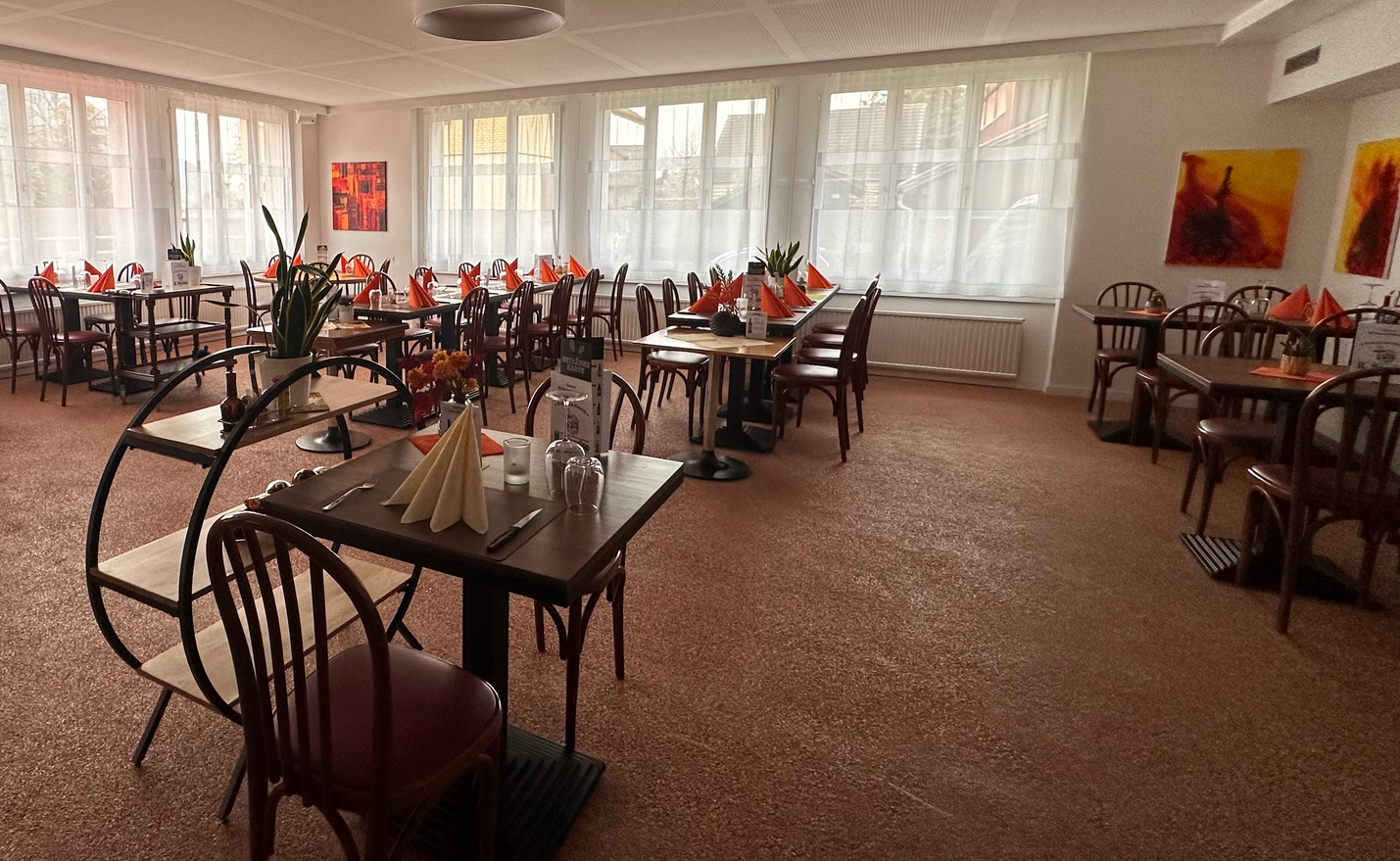 Une grande salle à manger remplie de tables et de chaises.