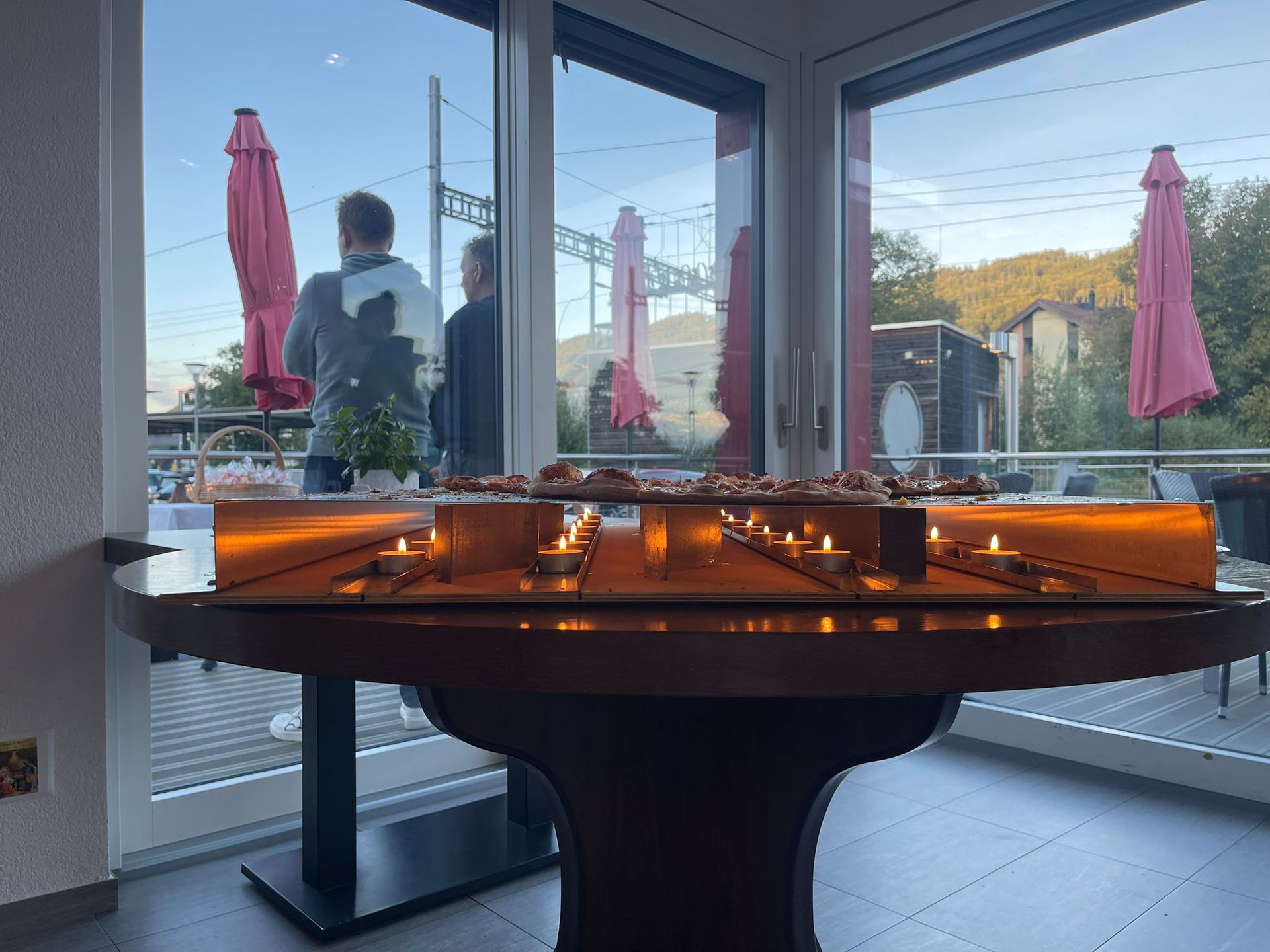 Une table avec des bougies dessus devant une fenêtre.