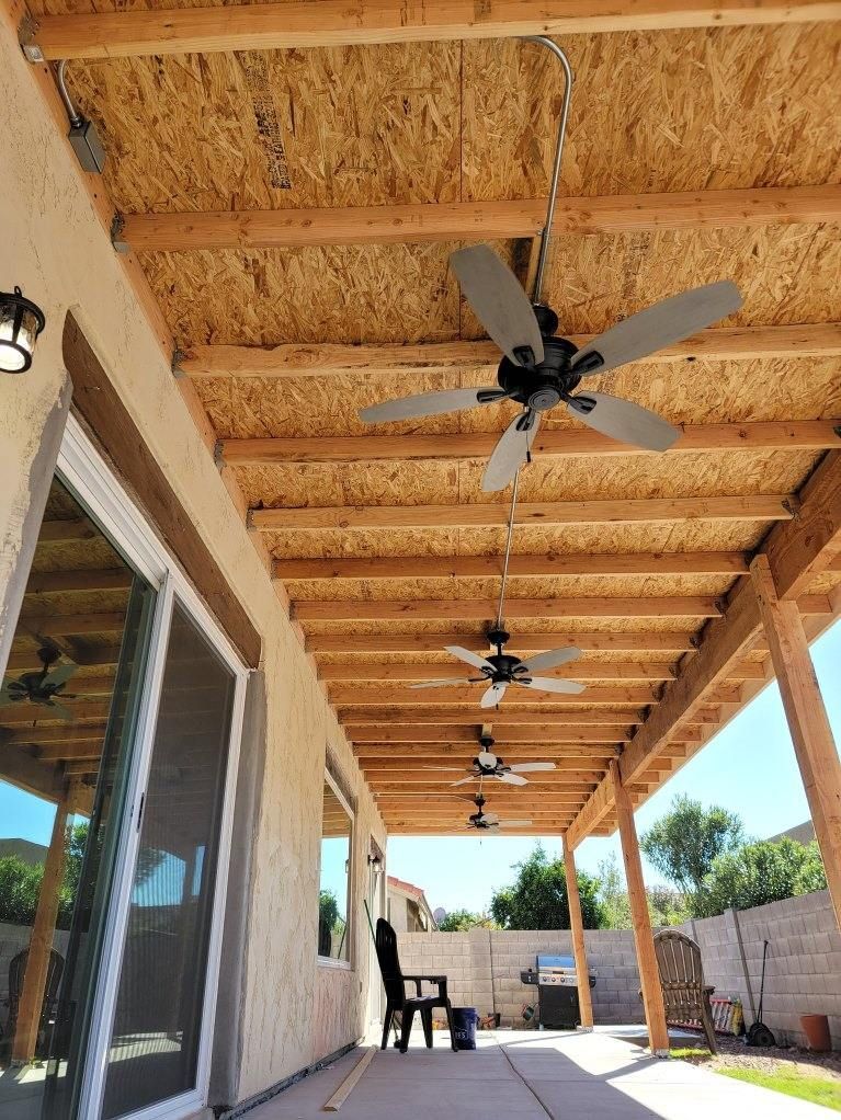 Several ceiling fans hanging from the ceiling of a covered patio after install by Oliver Electric