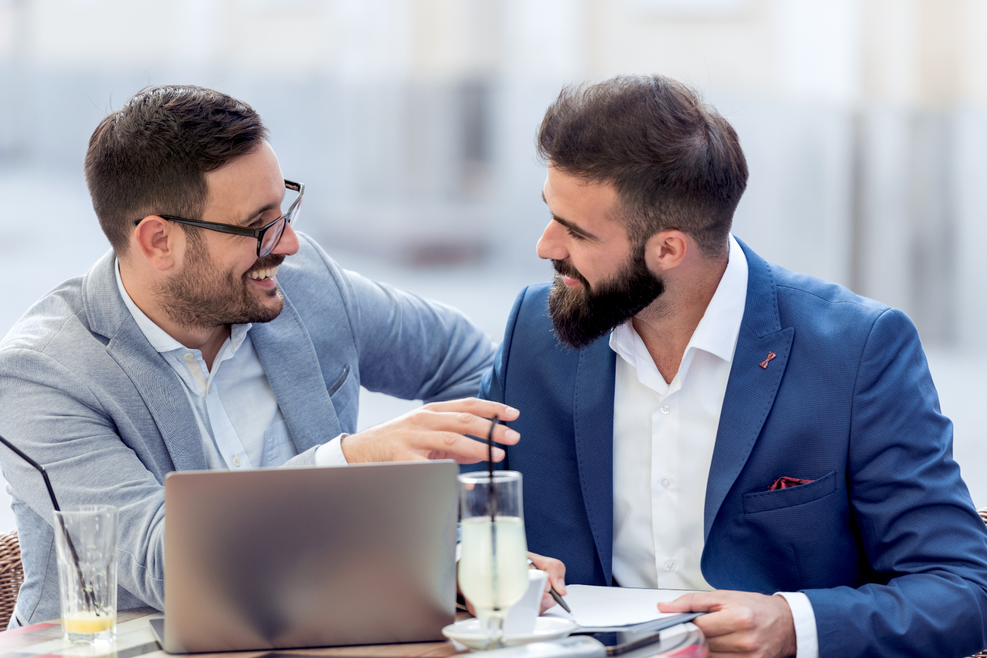 White apartment building with balconies, construction fence in front, blue sky.