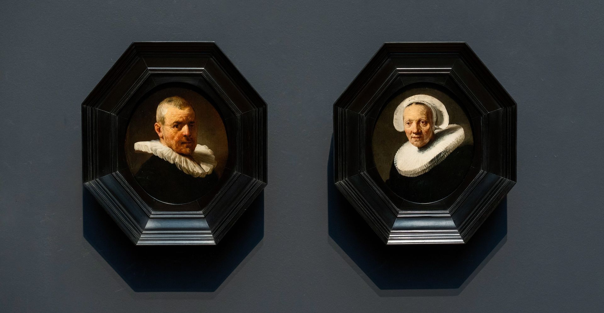 Foto van twee kleine door Rembrandt geschilderde portretten van familieleden.