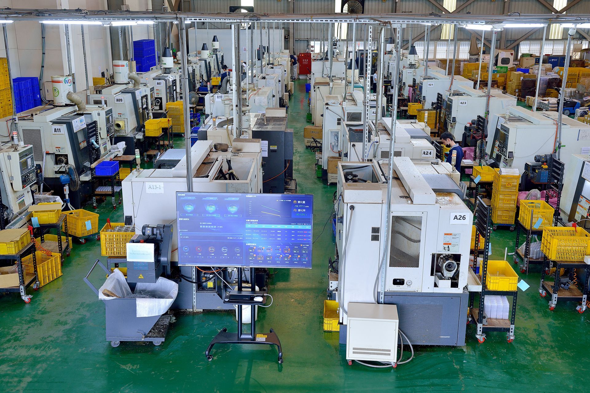 A large warehouse filled with lots of machinery and a large screen.
