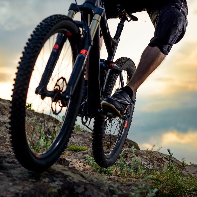 A person is riding a bike on a rocky hillside