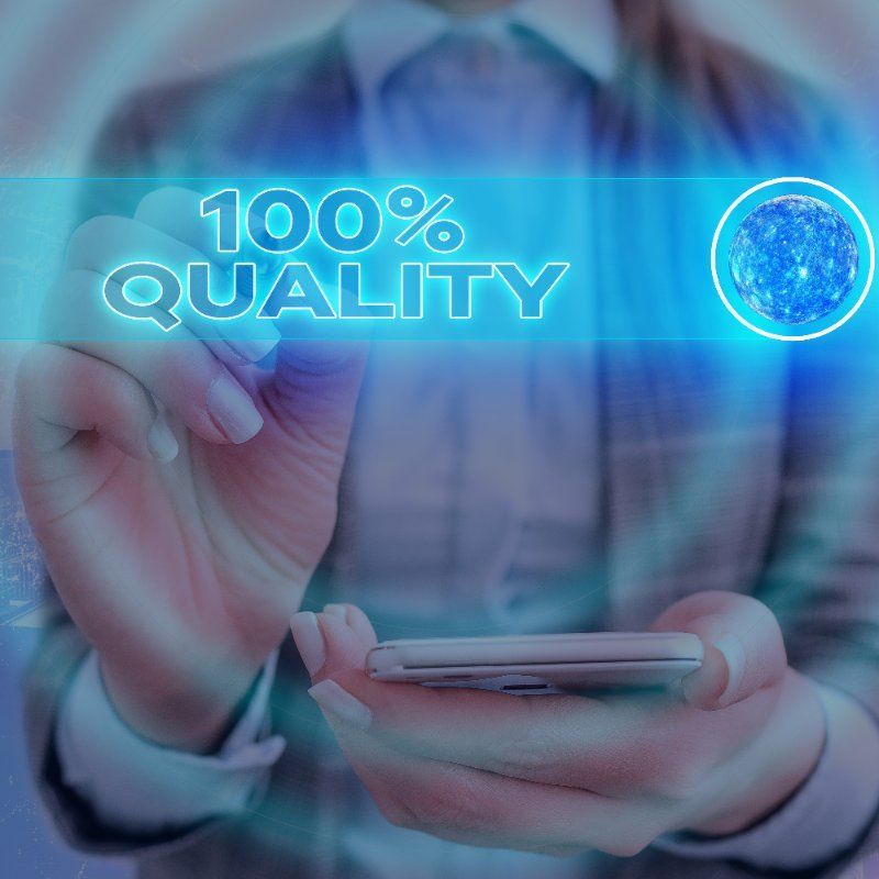 A person is holding a cell phone in front of a screen that says 100 % quality