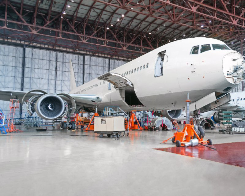 A large passenger jet is being repaired in a hangar.