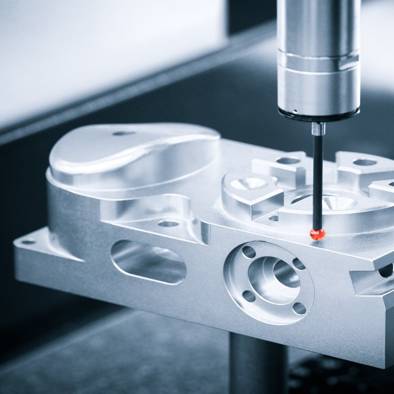 A machine is measuring a piece of metal with a red dot on it