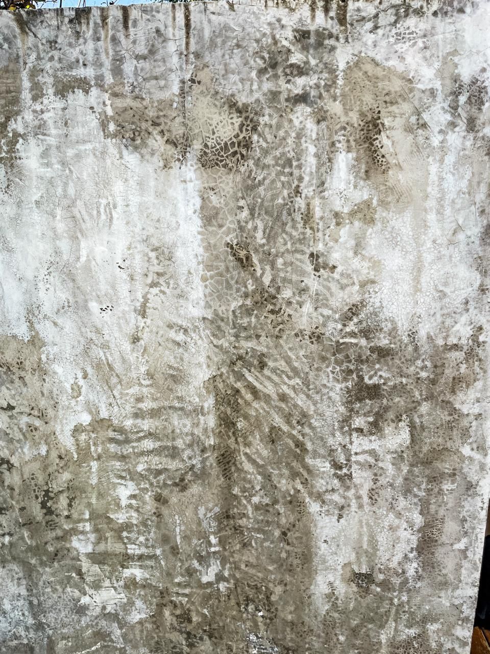 Un primer plano de una pared de hormigón con muchas manchas.