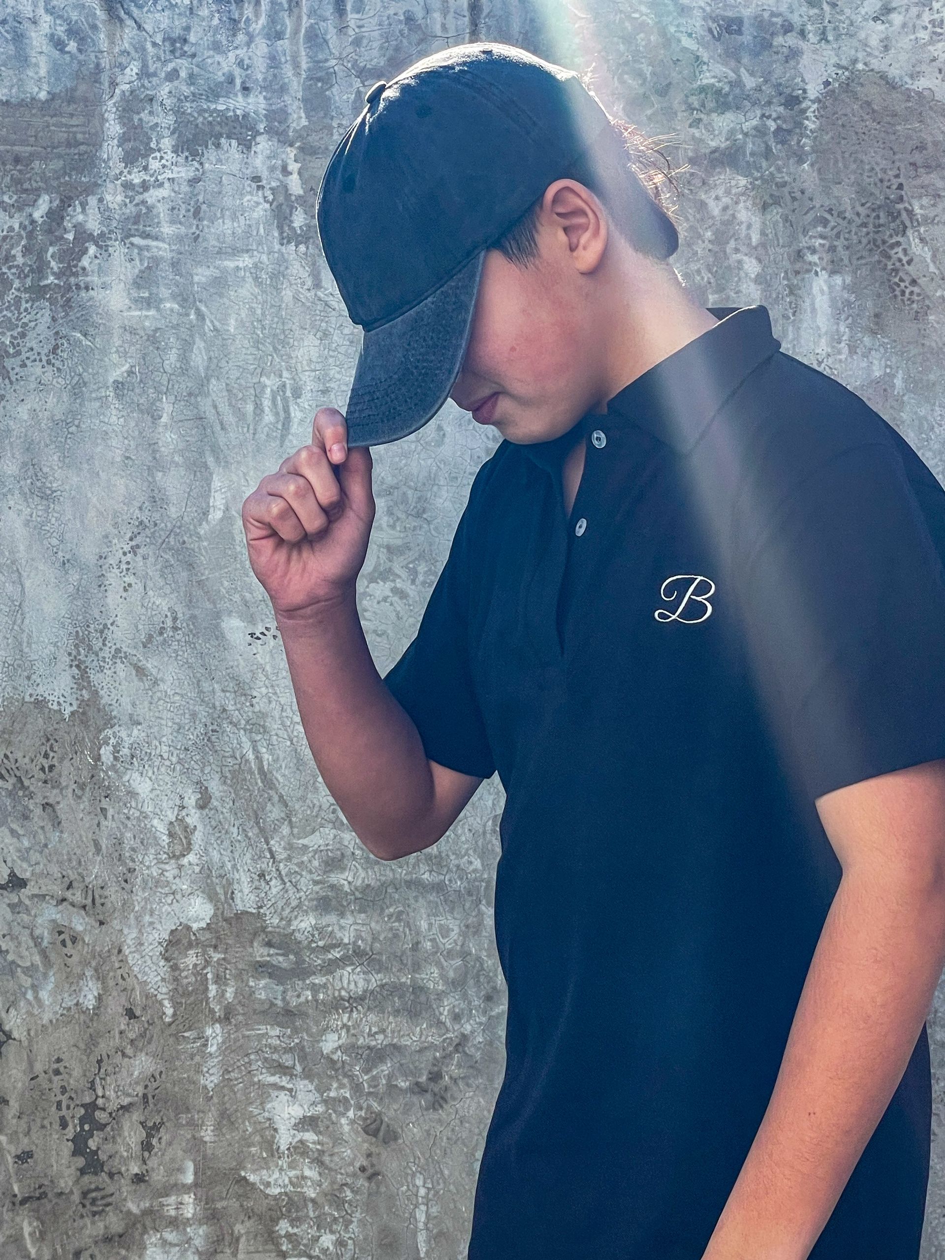 Un niño que lleva una camiseta negra con la letra f.