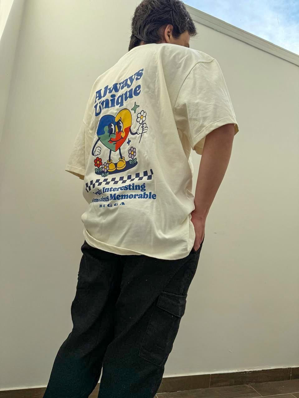 Un hombre lleva una camiseta blanca con un personaje de dibujos animados en la espalda.