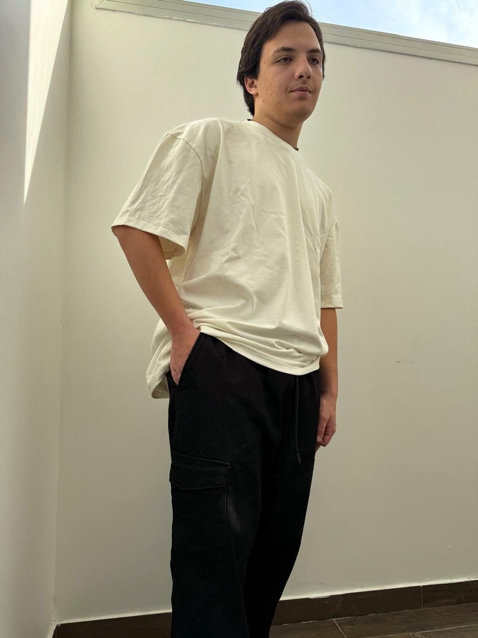 Un hombre lleva una camiseta blanca con un personaje de dibujos animados en la espalda.