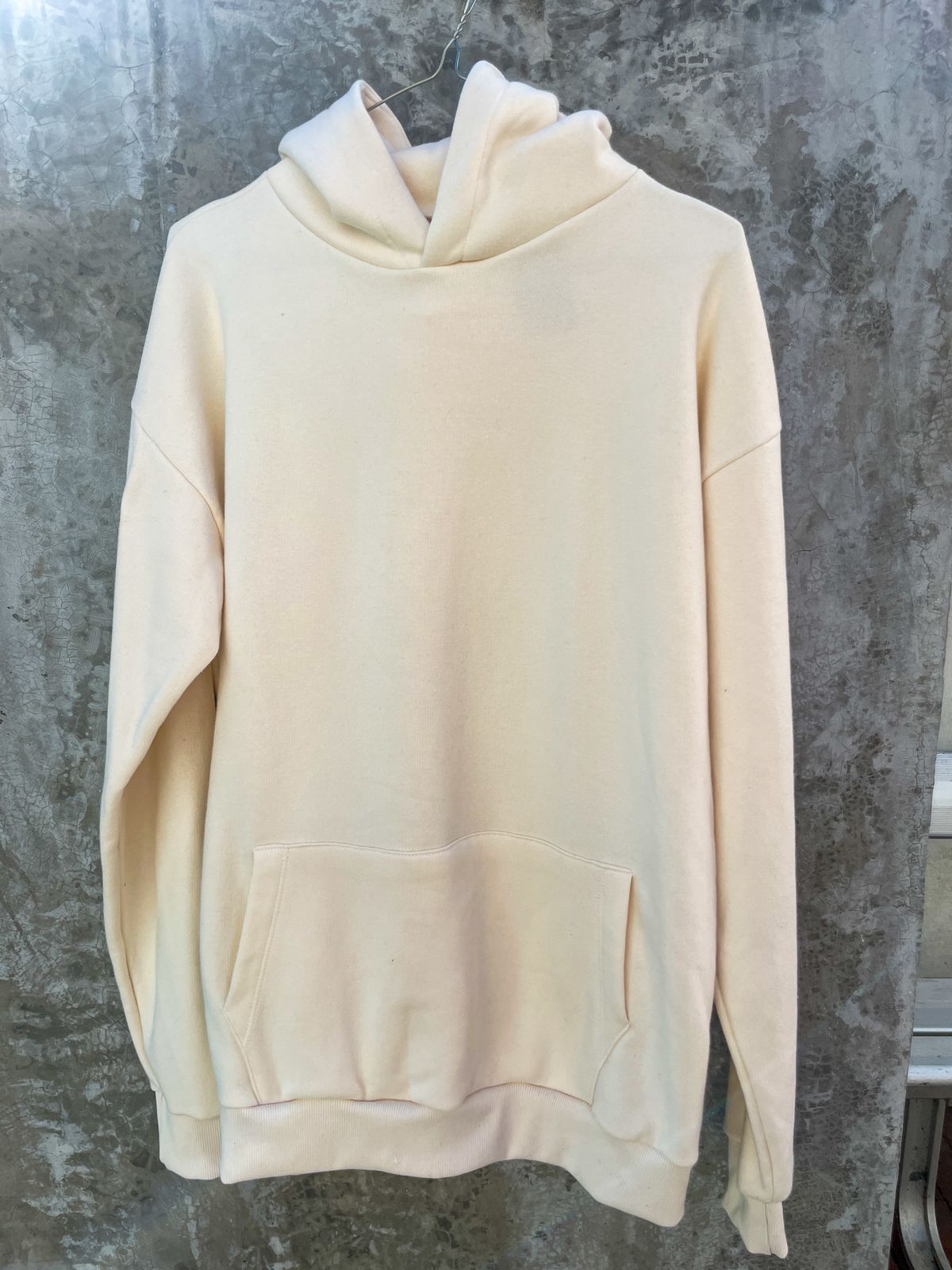 Una sudadera blanca está colgada en una pared.