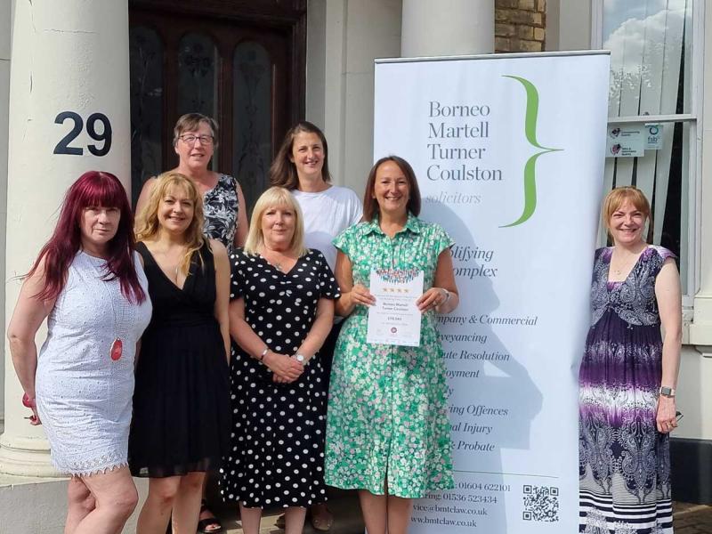A group of women standing in front of a sign that says 29