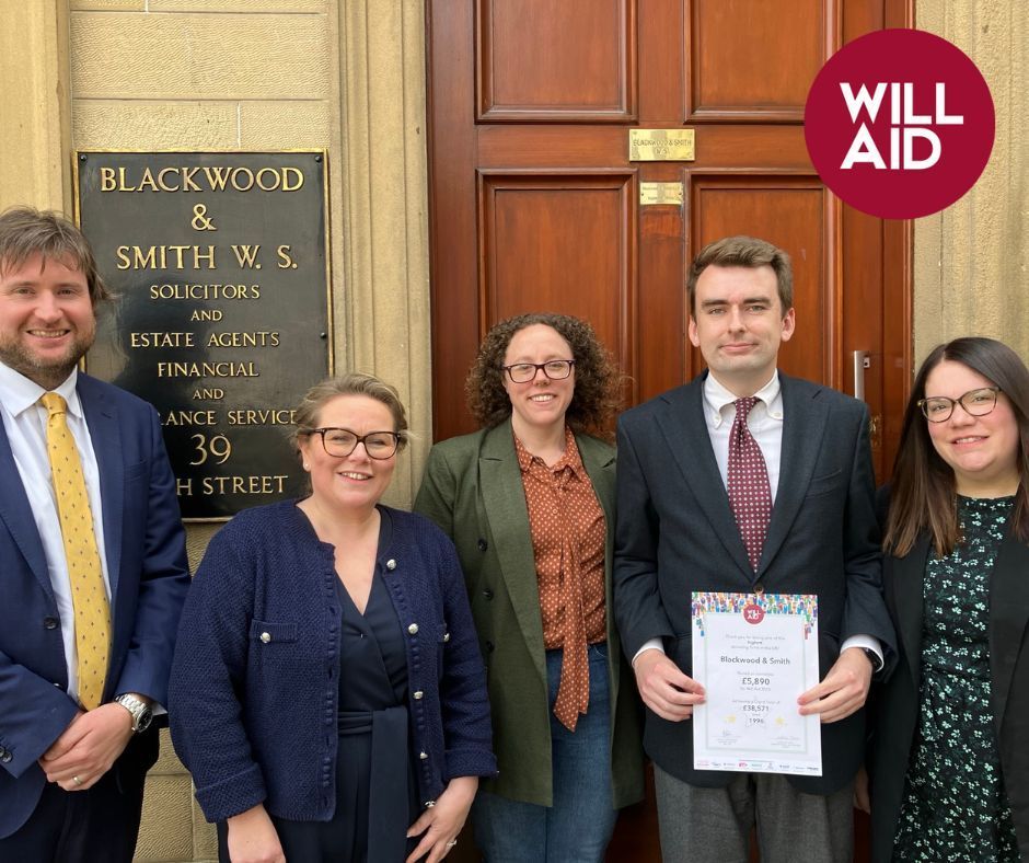 A group of people standing in front of a building with a sign that says will aid.